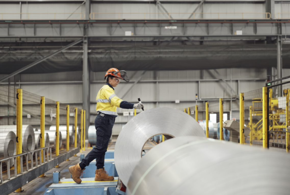BlueScope employee working in a facility inspecting steel rolls
