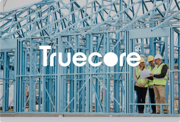 A building frame made from BlueScope's TRUECORE® steel with three people looking at the plans