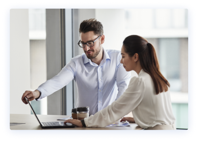 Two BlueScope employees reviewing work on laptop in an office environment