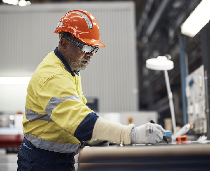 BlueScope employee writing on workbench