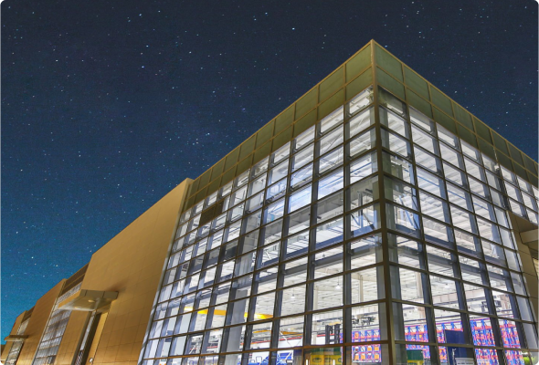 Exterior shot of a modern glass building beneath a starry sky