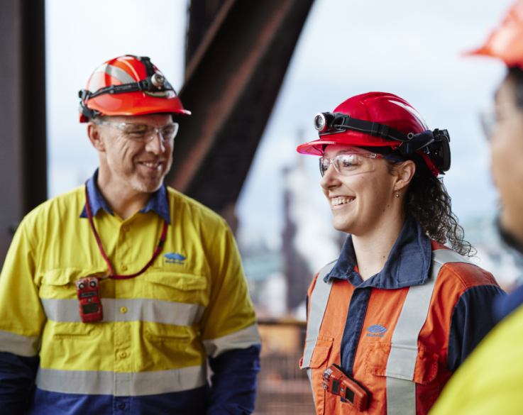 Two BlueScope employees smiling and posing for a photograph