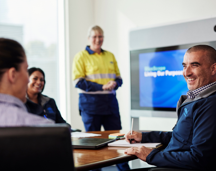 Employee wearing TRUECORE® shirt seated in a facility and posing for a photograph