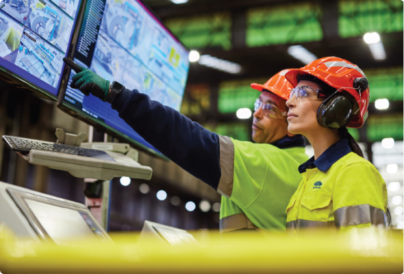 Two BlueScope employees examine monitoring equipment in a facility