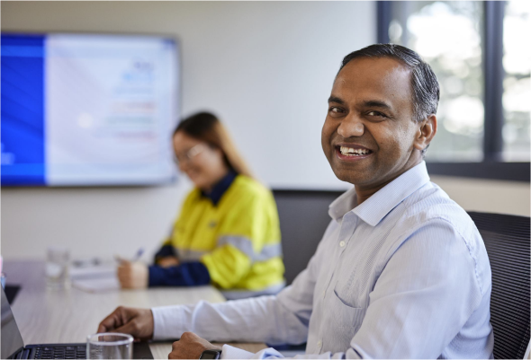 Male BlueScope employee smiling for a photograph in a meeting room
