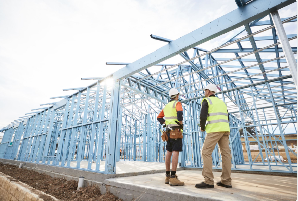 A building frame made from BlueScope's TRUECORE® with two people carrying out a site inspection.
