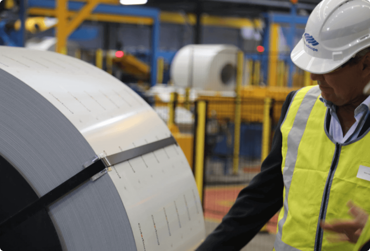 Man inspecting sheet metal roll in facility