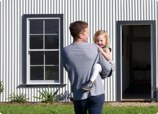 Dad and daughter walking towards house in the garden